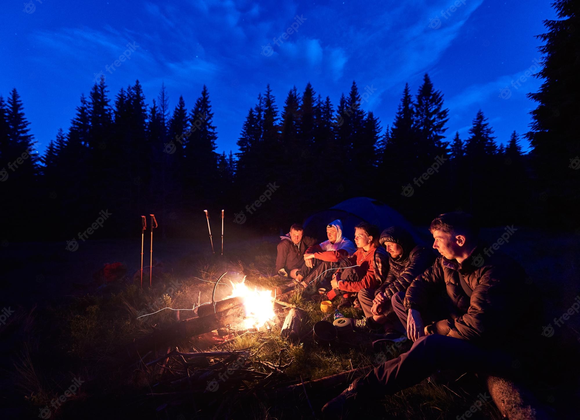 People Sitting Around Campfire In Dark Night Wallpapers