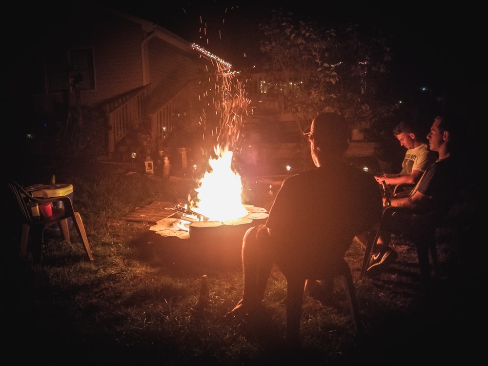 People Sitting Around Campfire In Dark Night Wallpapers