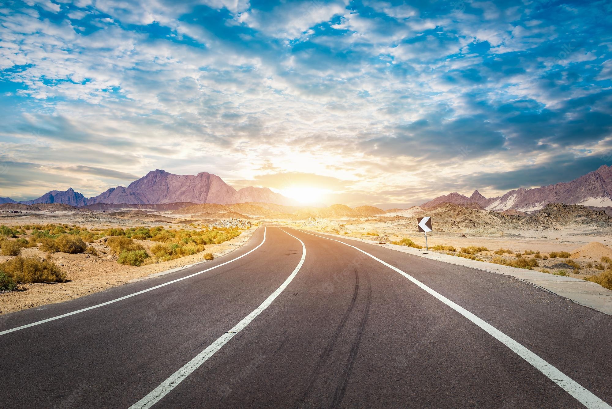 Road With Background Of Mountains And Clouds